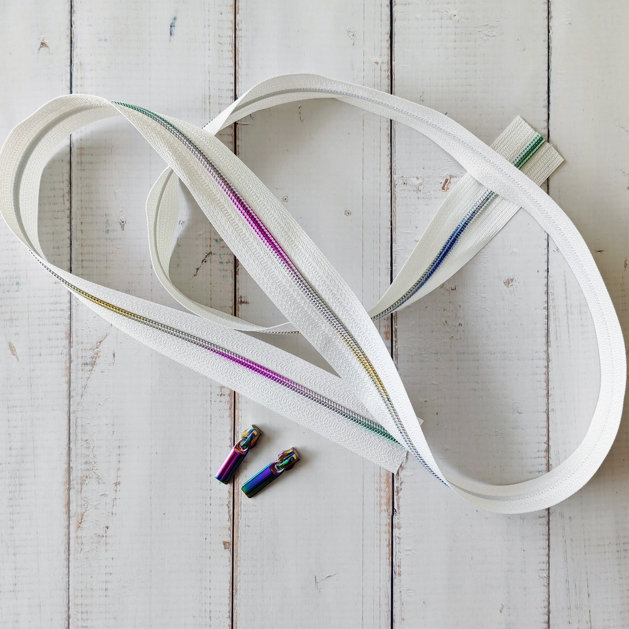 White zipper with colorful zipper pulls. 