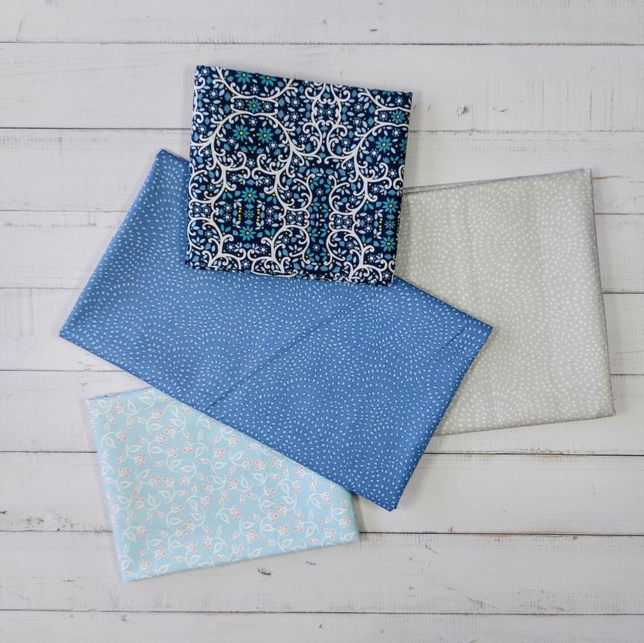 Four pieces of blue and grey fabric with different patterns 
