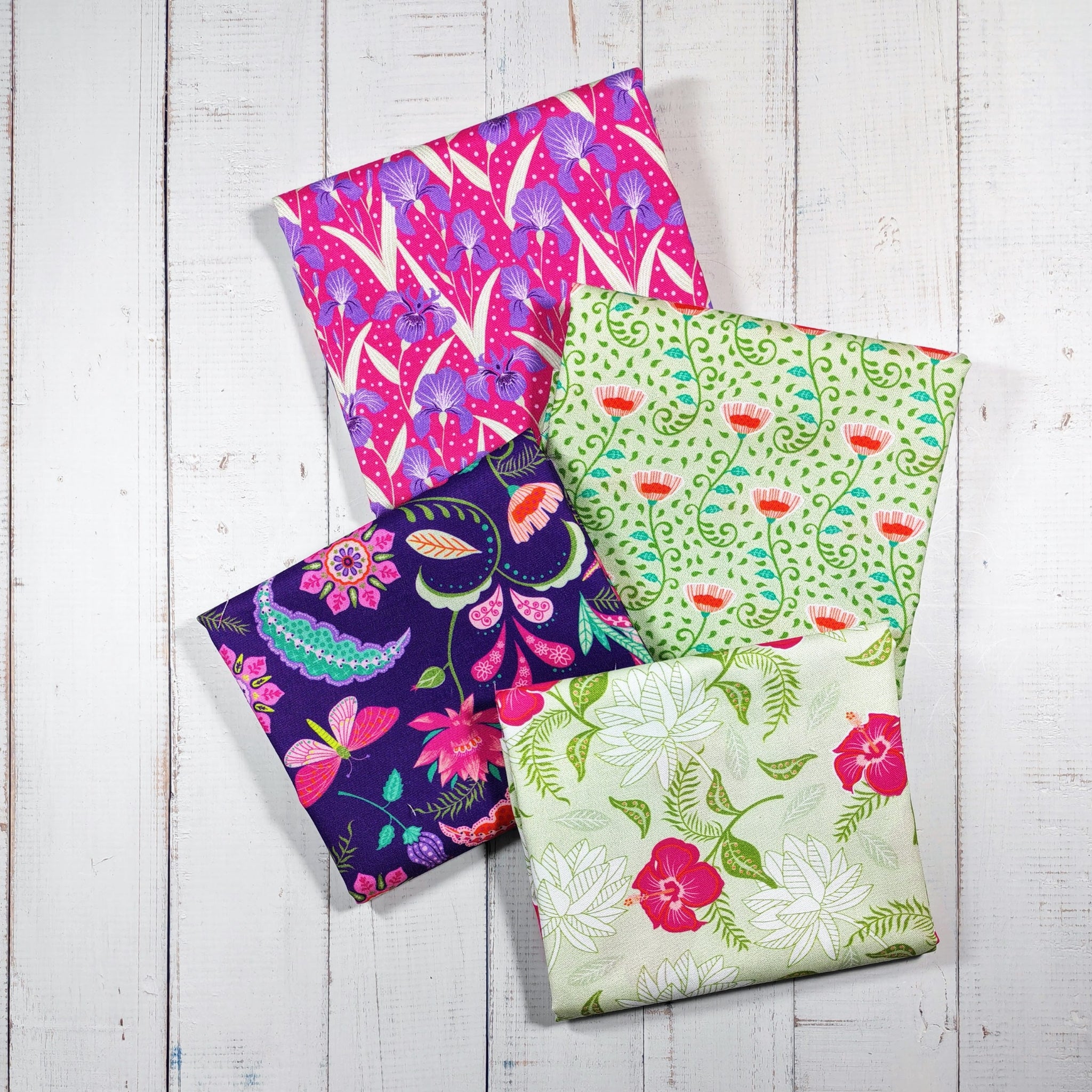 Four colorful fabric fat quarters with floral patterns