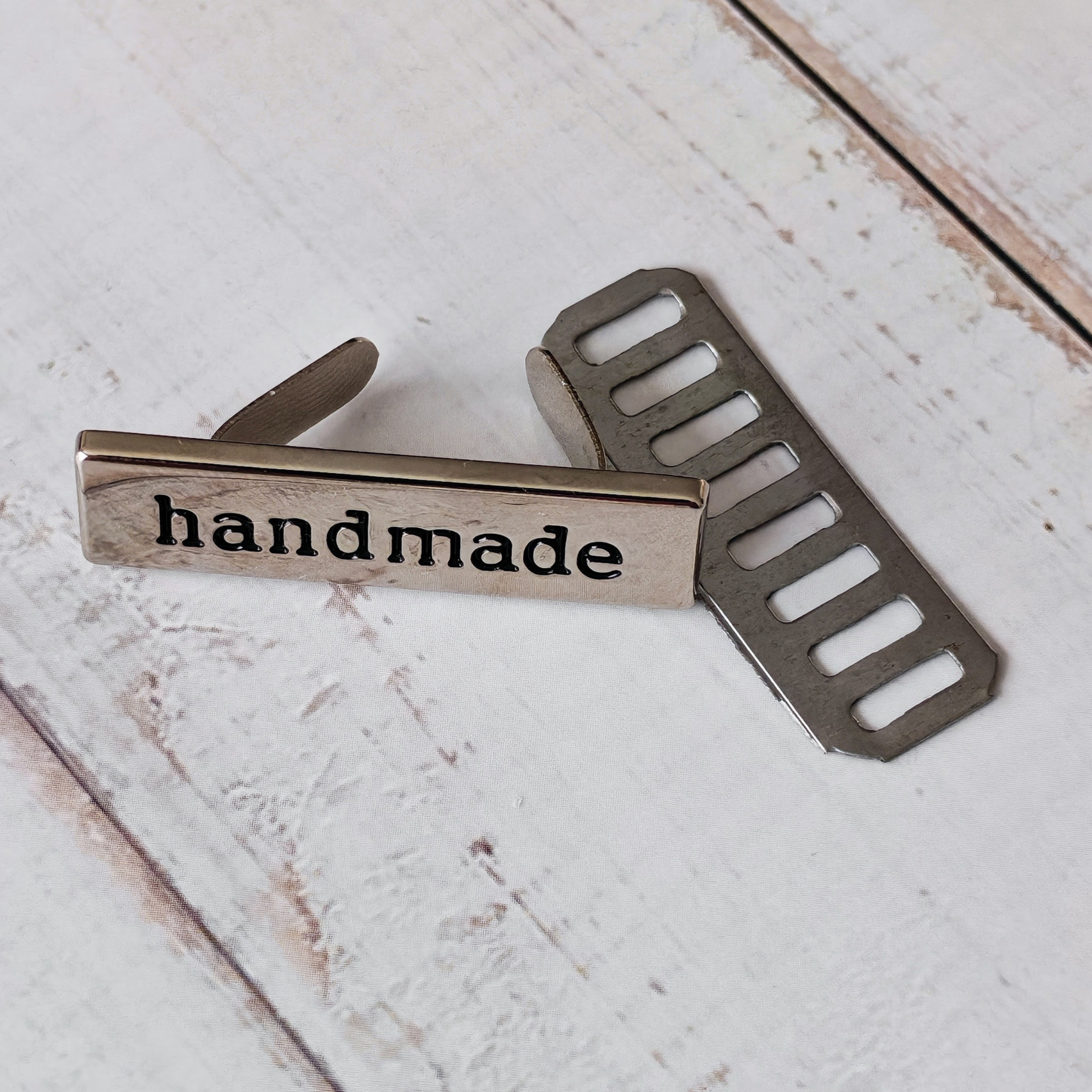 Silver coloured metal 'handmade' tag.