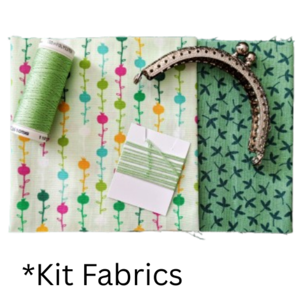 Two fabrics, one with a colorful vertical floral pattern on a pale green background and the other in a light green leaf print, with a spool of green thread and a metal purse frame.