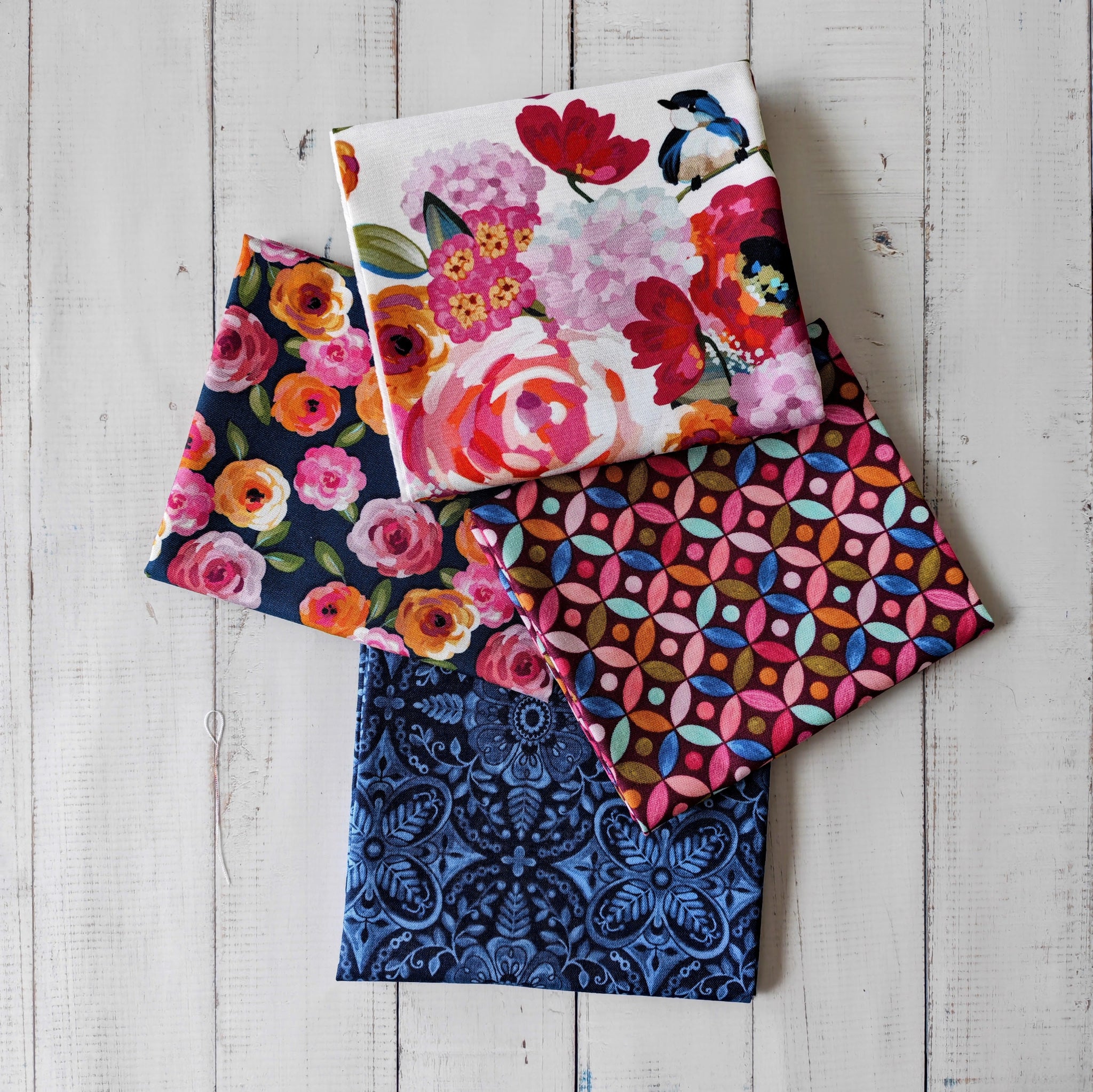 Stack of colorful fabric swatches on a wooden surface