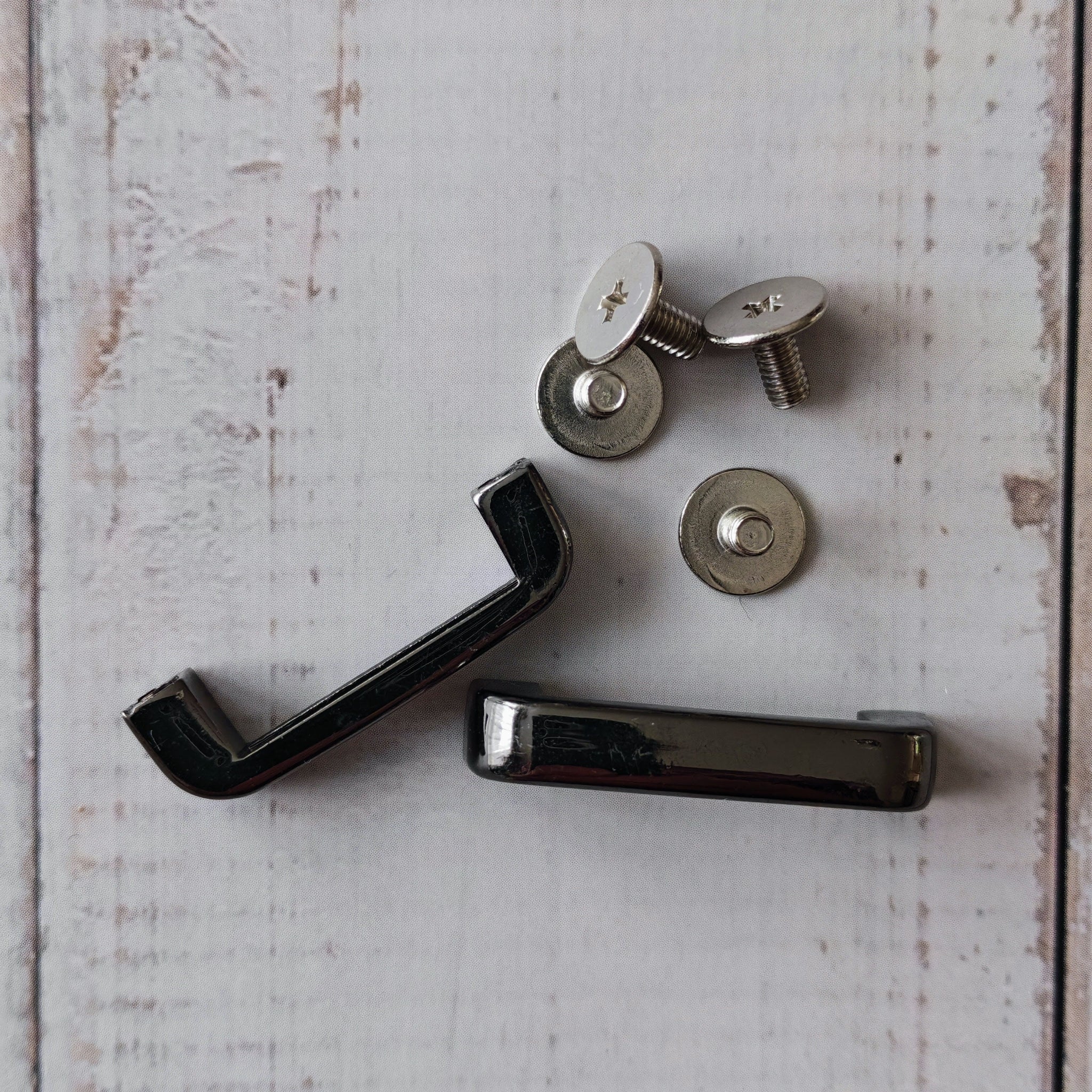 Gun metal coloured strap keepers for bags.