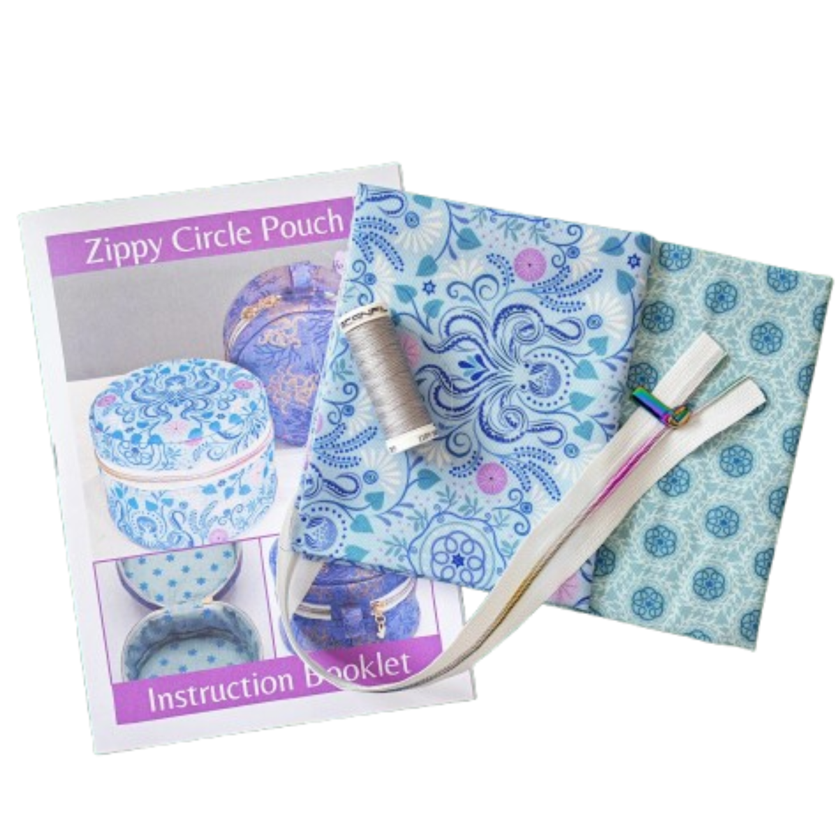 A zippy circle pouch kit laid out on a white background, including a printed instruction booklet, two patterned fabrics, a spool of thread, and one zipper.
