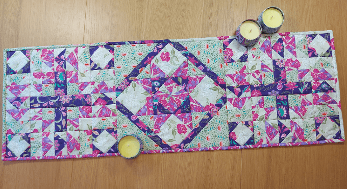Quilted table runner with geometric pattern on a wooden surface